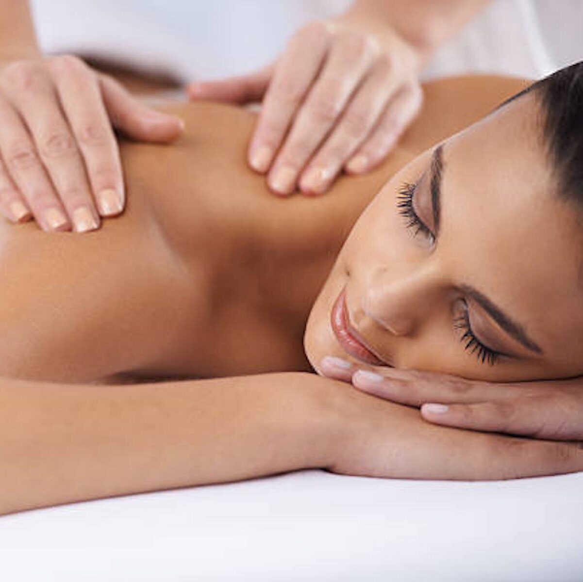 A young woman receiving a massage from a massage professional